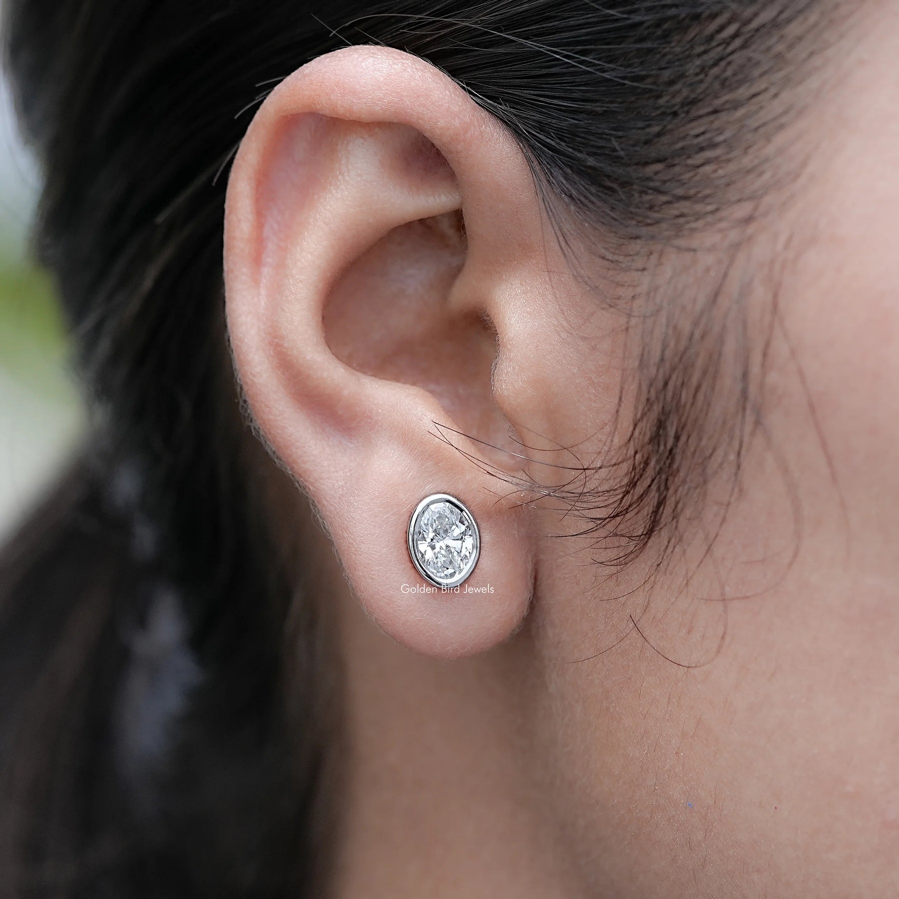 In Ear View of Bezel Set Oval Cut Lab Diamond Stud Earrings