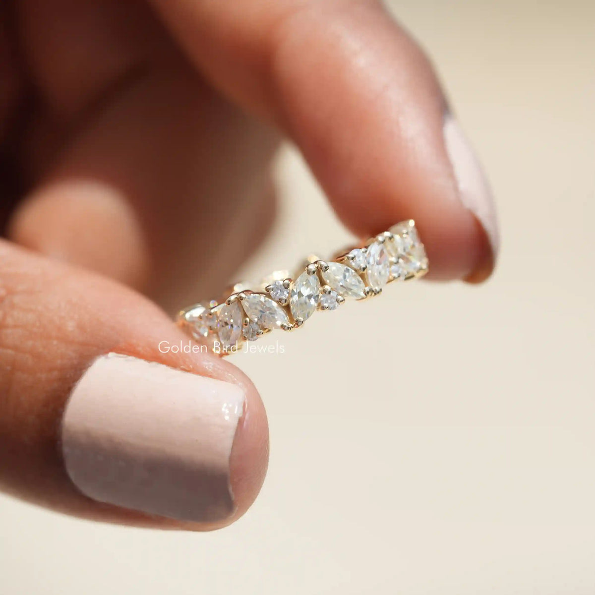 Front view of Marquise And Round Moissanite ring holding in two fingers 