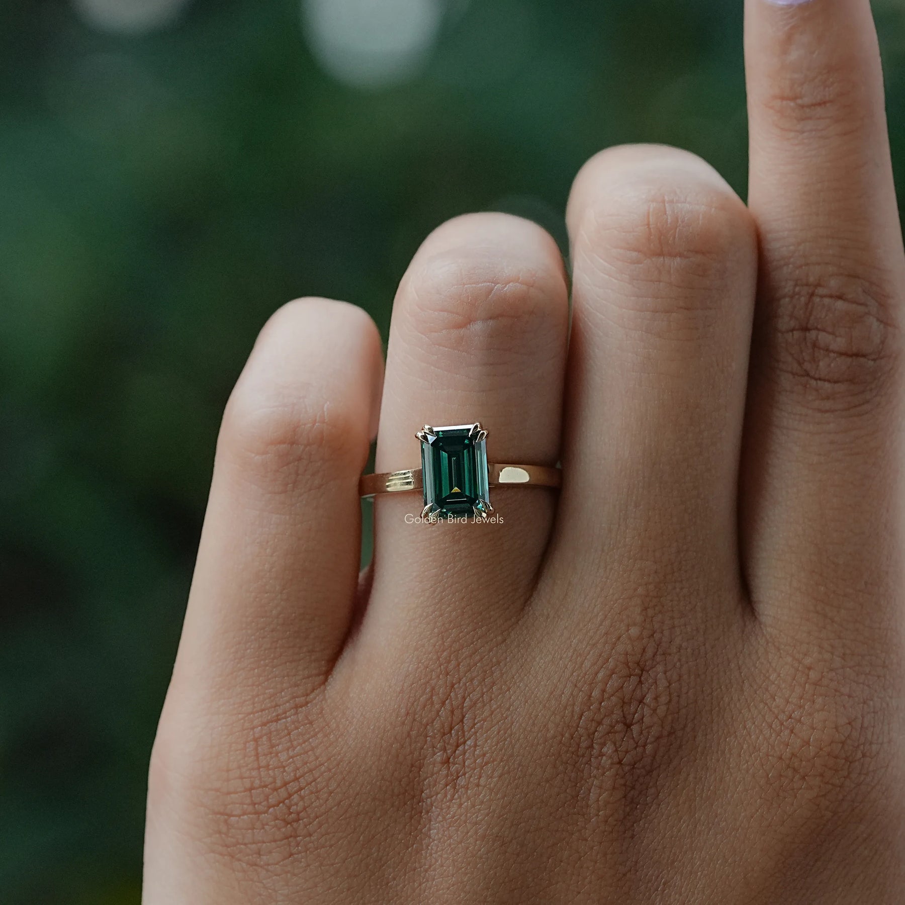 In Finger close view of moissanite  ring in yellow gold 
