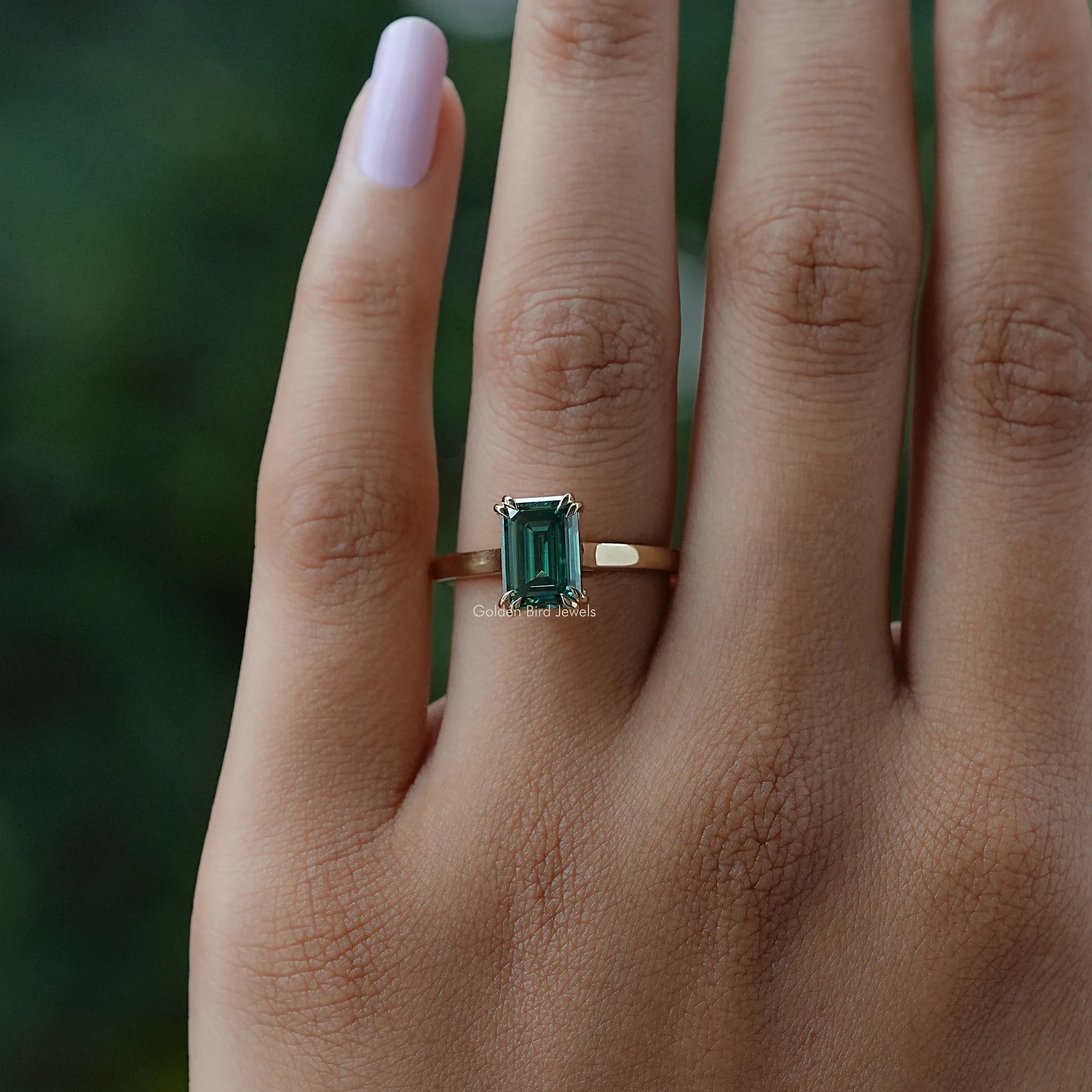 In finger view of halo emerald moissanite  ring 