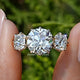 Square Old Mine Cushion Diamond Three Stone Ring Held Between Fingers