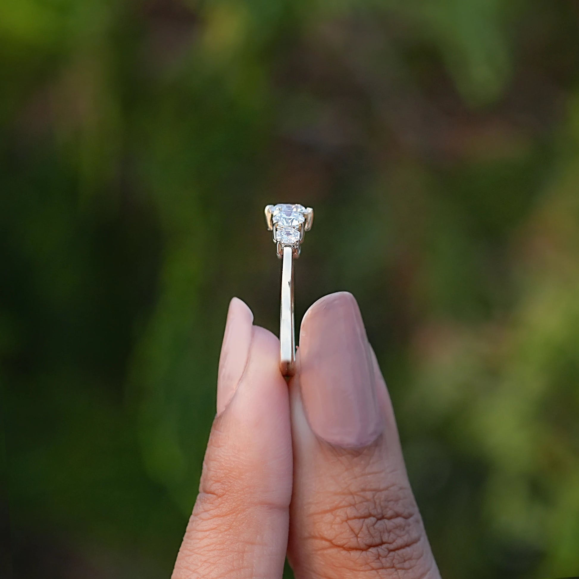 Side View of Round Cut Diamond Five Stone Ring In two fingers