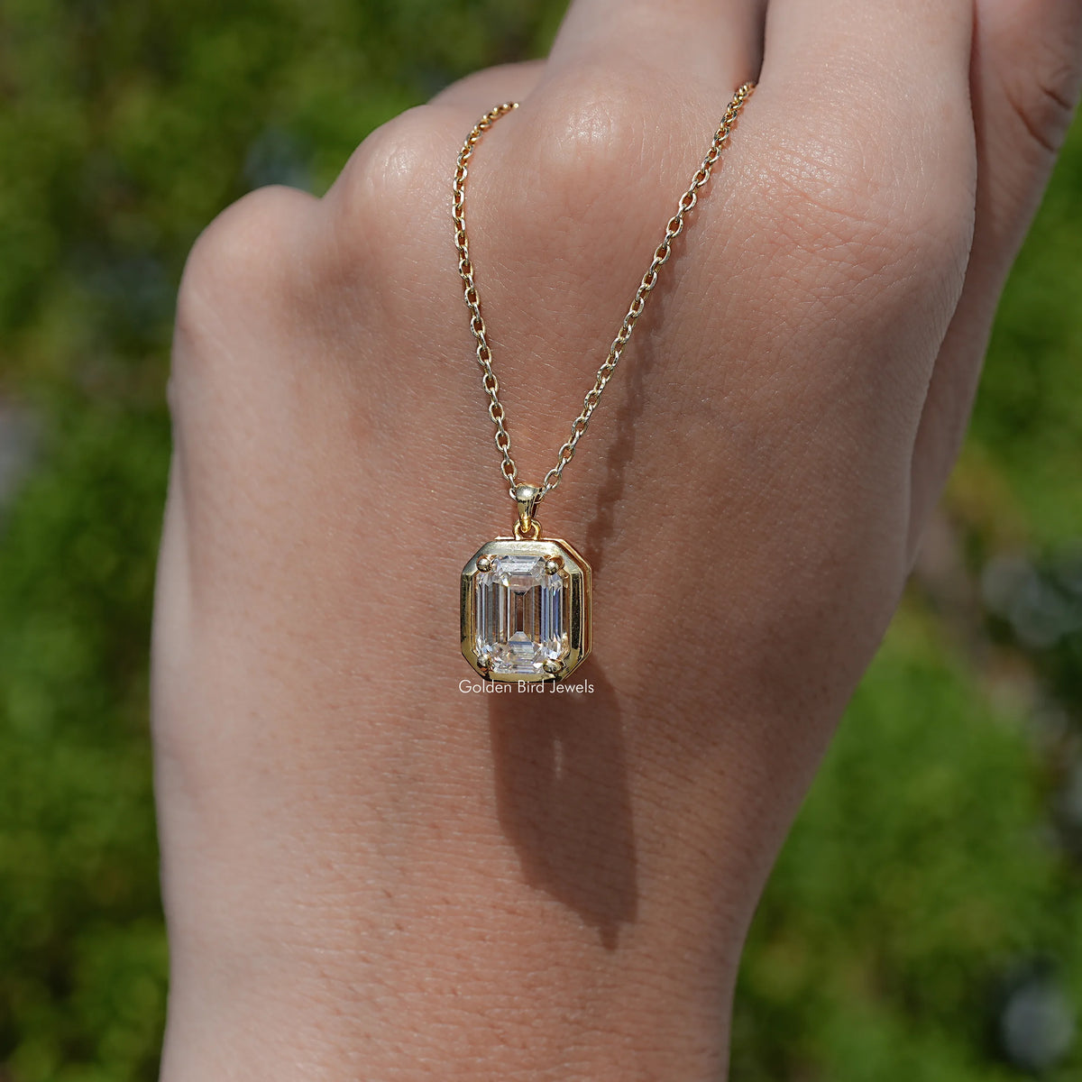 hand Showing View of Emerald Shaped Moissanite Pendant
