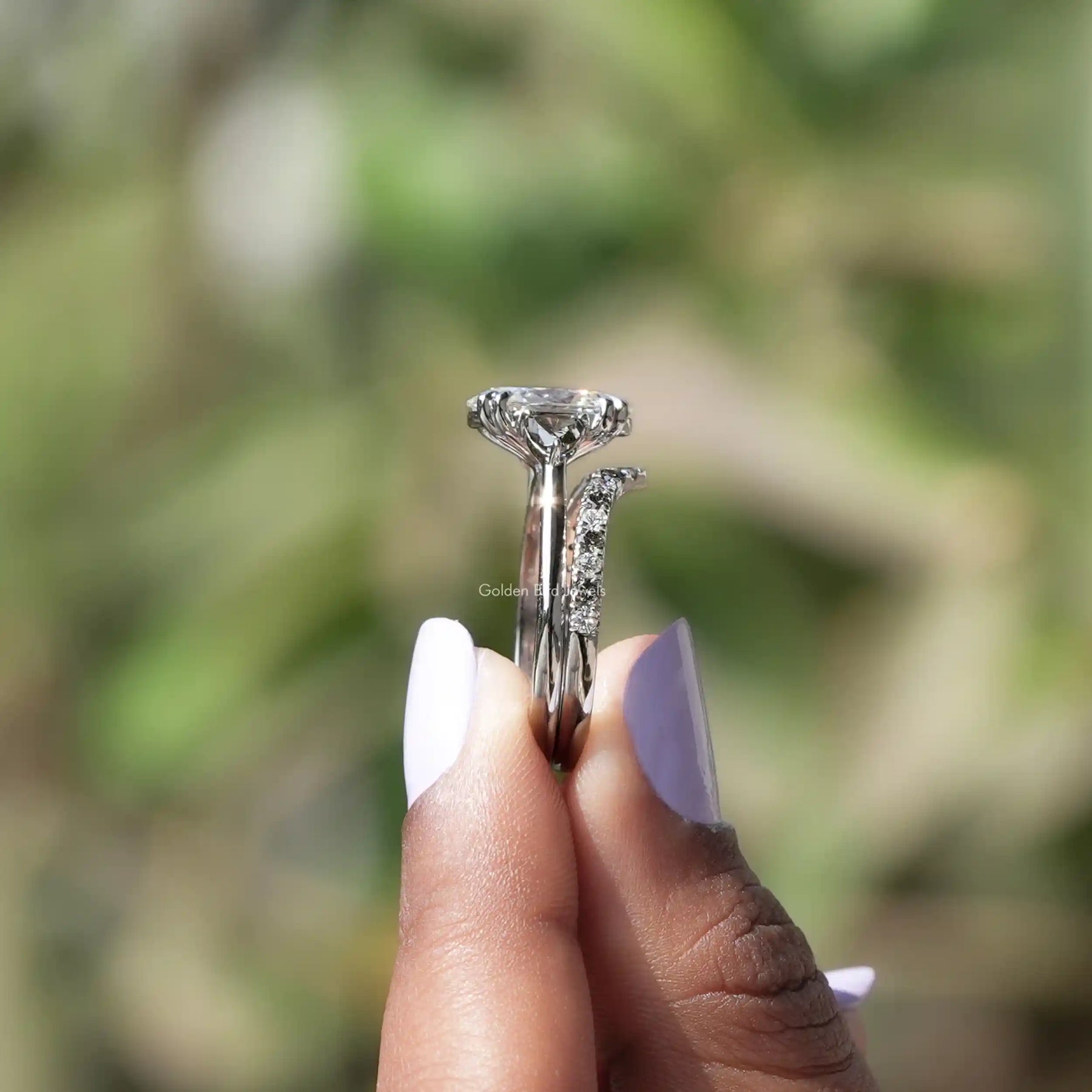 Side View of Oval Cut Lab Grown Diamond Ring In two fingers