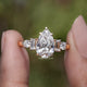Pear And Baguette Cut Lab Diamond Five Stone Ring Between Two Fingers