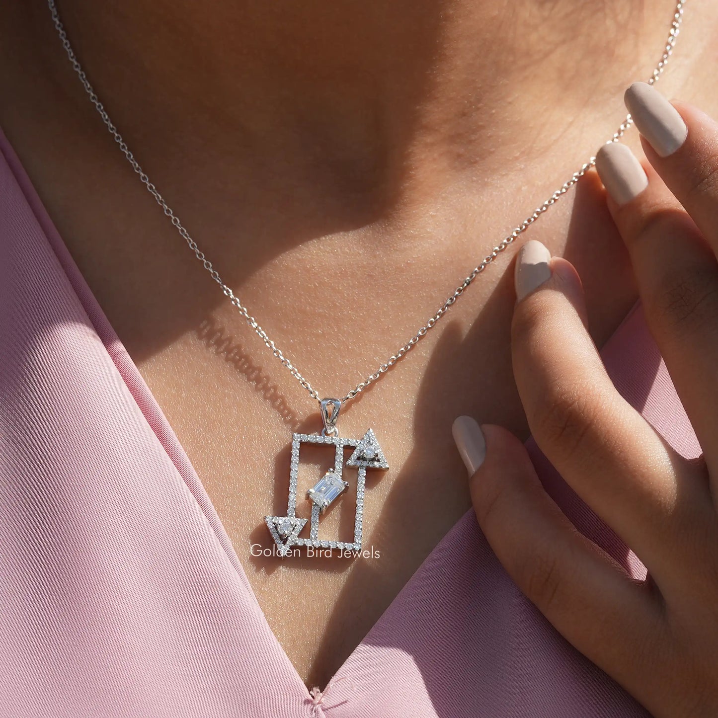 In neck front view of round and emerald cut white gold pendant