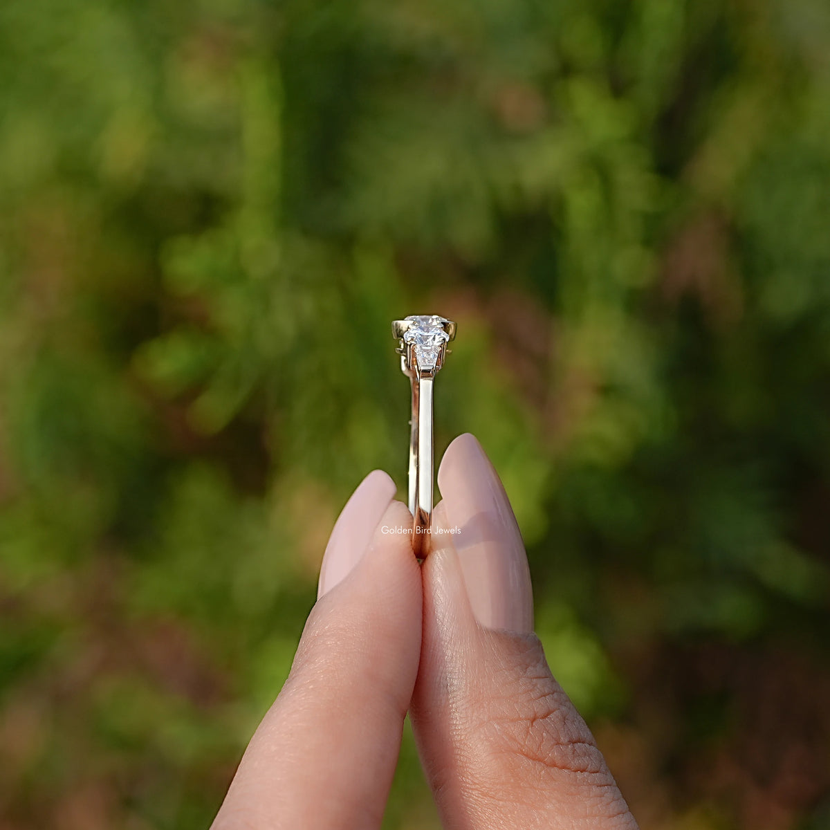 Side View of Round Cut Diamond Engagement Ring In two fingers