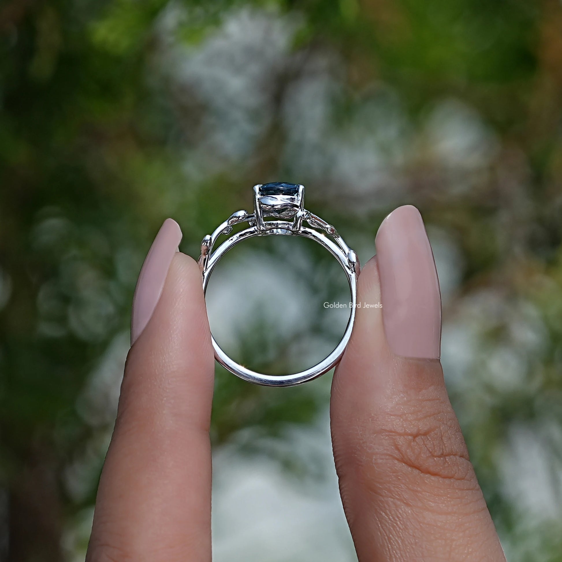 Back View of Oval Cut Blue Sapphire Gemstone Solitaire Ring In two fingers