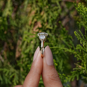 Side View of Cushion Cut Diamond Three Stone Engagement Ring In two fingers