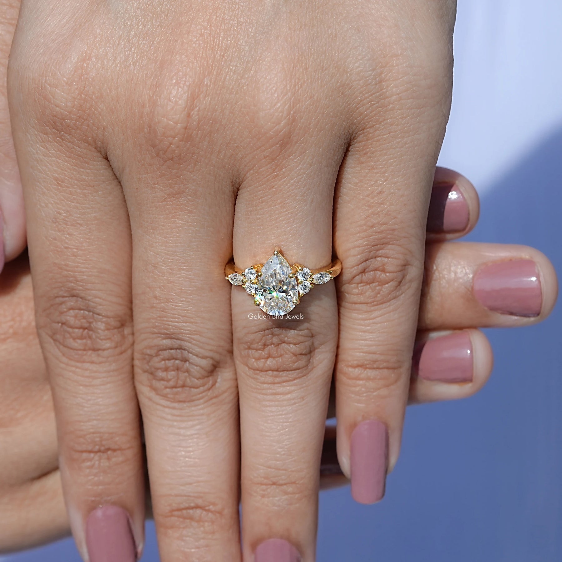 In finger front view of Pear cut moissanite Accent engagement ring  in unique shape
